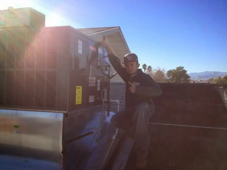 HVAC technician performing HVAC Inspection on a rooftop unit in Spencer